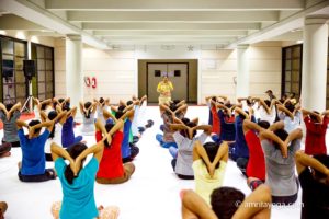 amrita yoga group doing seated arm reverse namaste