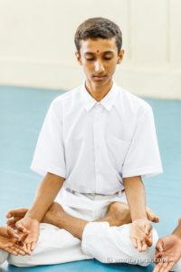 young man white clothes meditating padmasana