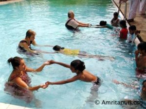 amritapuri residentes ensinando as crianças da aldeia a nadar